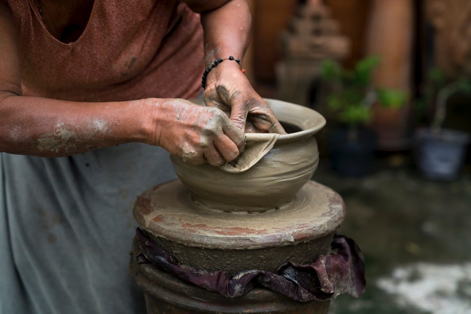 woman making clay pot