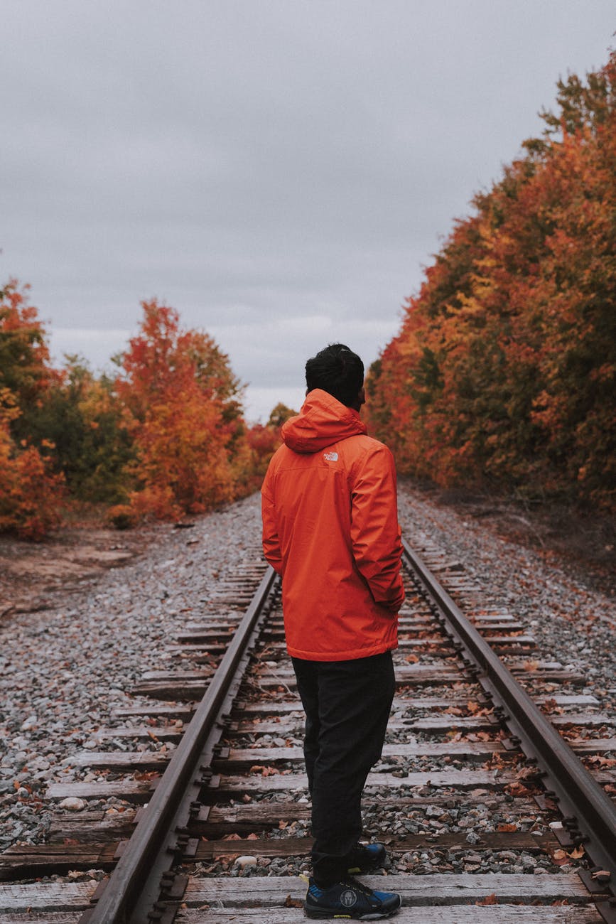 man standing on railroad