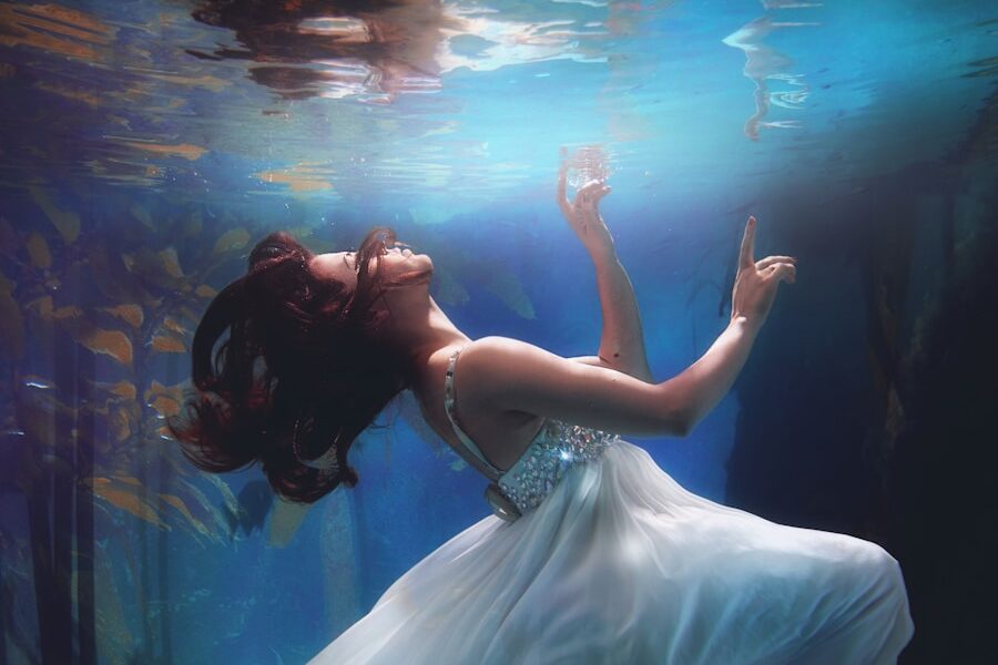 underwater photography of woman wearing white dress